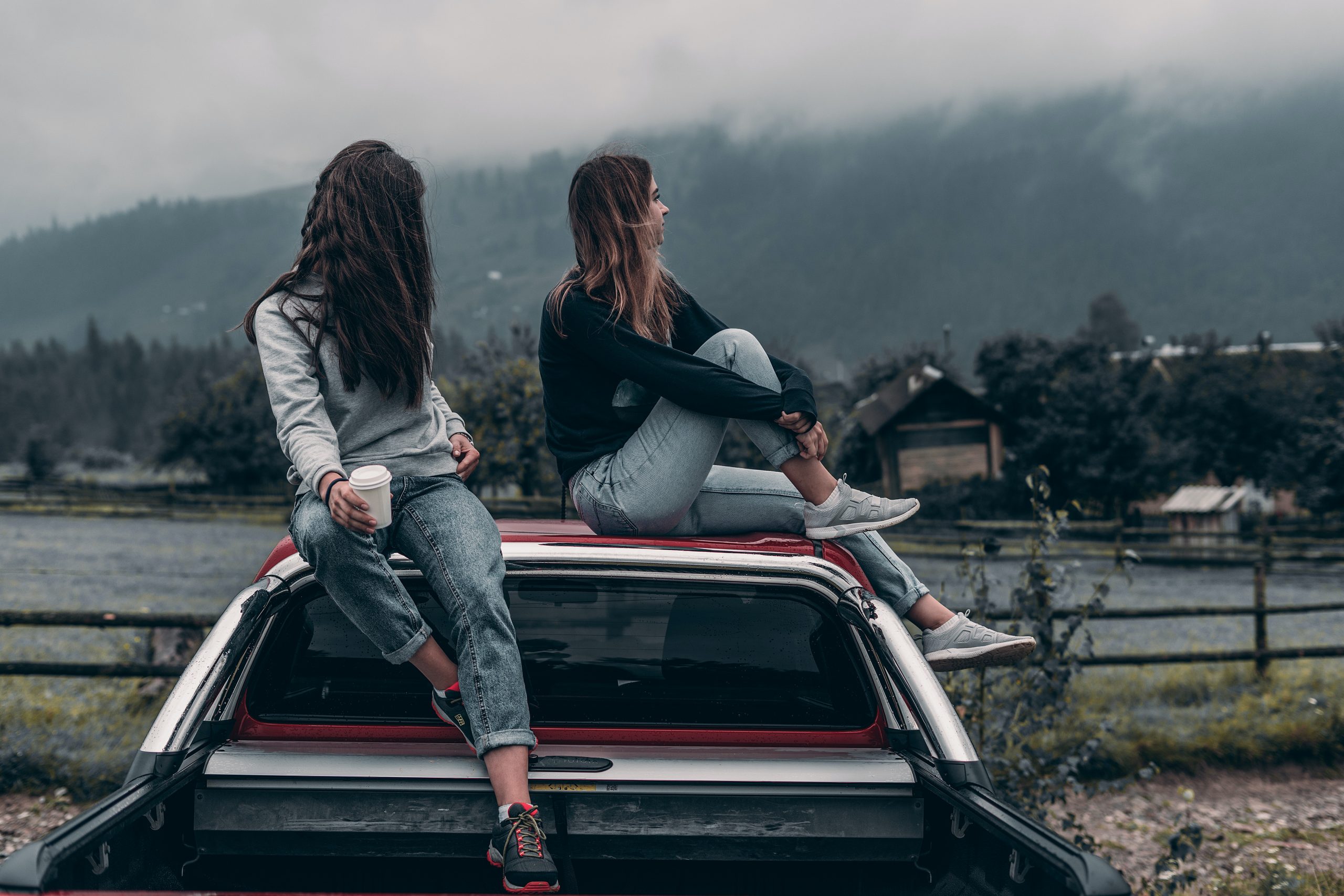 two-women-sitting-on-vehicle-roofs-2409681