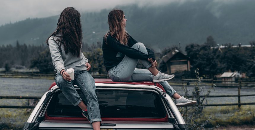two-women-sitting-on-vehicle-roofs-2409681